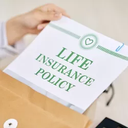 Woman removing Life Insurance Policy from legal envelope