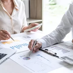 Couple looking over financial reports at their kitchen table